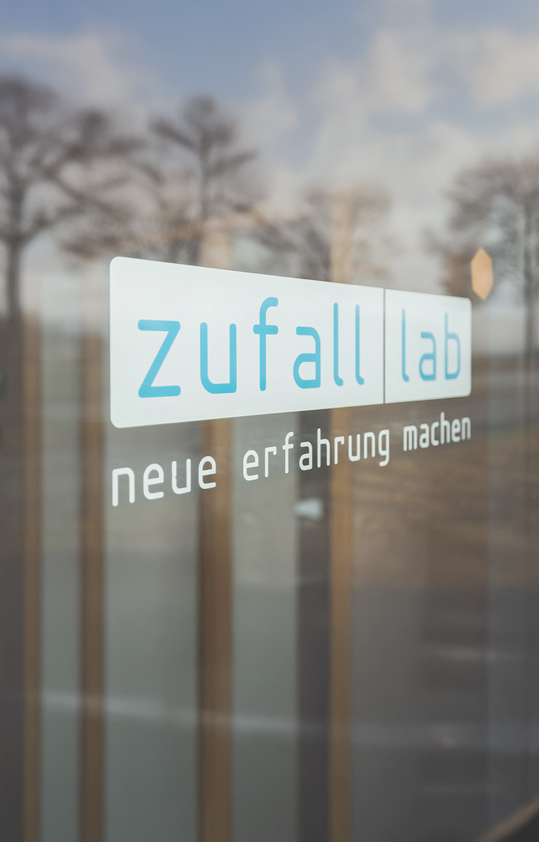 zufall.lab Logo auf einer Fensterschreibe